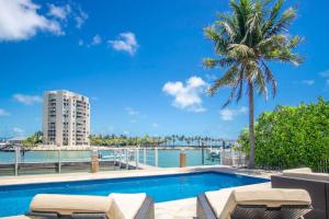a swimming pool with a palm tree and a building at Oceans Edge Retreat in Key Colony Beach