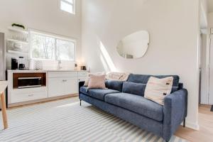 a living room with a blue couch and a kitchen at Sweet Tea Cottage 1BR and Loft in Murfreesboro