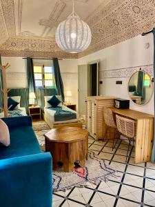 un soggiorno con un divano blu e un tavolo di Riad Green Vines a Marrakech