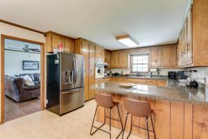 une cuisine avec un réfrigérateur en acier inoxydable et des armoires en bois dans l'établissement Southall Cottage 3bd Serene Outdoor Space, à Franklin