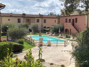 Una piscina en un patio con un edificio. en vicino a San Gimignano, relax tra piscina e natura, fast internet STARLINK, en Gambassi Terme