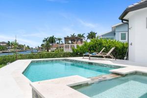 a swimming pool with a table and a chair next to a house at Gulf Breezes in Marco Island