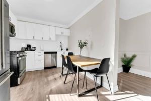 a white kitchen with a wooden table and chairs at RentX 3Bed Cozy Home - Hospital GO 2ParkingWi-Fi in Hamilton +39 photos