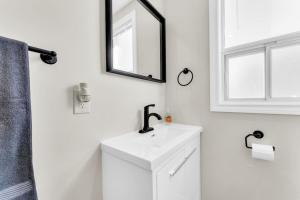 a white bathroom with a sink and a mirror at RentX 3Bed Cozy Home - Hospital GO 2ParkingWi-Fi in Hamilton