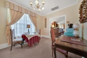 a dining room with a table and a desk and a window at Timeless Victorian Gem w Breathtaking Mountains in Sutter Creek