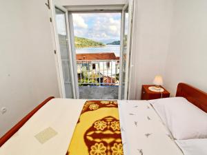 a bedroom with a bed and a large window at Apartments Nodilo - One Bedroom Apartment with Balcony and Sea View Apt 1 in Goveđari