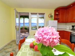 - une cuisine avec une table et une fleur rose dans l'établissement Apartments Stipo - Comfort One Bedroom Apartment with Terrace and Sea View A1, à Drače 19 autres photos