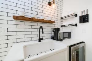 a white kitchen with a sink and a microwave at Faraway Geodome with Views in Luray