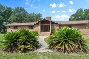 a house with two palm trees in front of it at Astor Manor At Rivers Edge in Astor