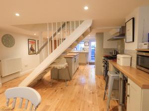 a kitchen and living room with a staircase in a house at Stones Throw Cottage in Ambleside