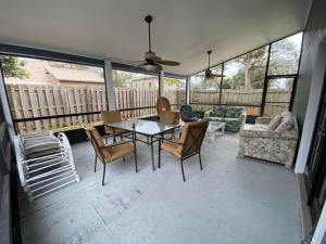 a screened in porch with a table and chairs at Relaxing 3 bed 2 bath home by the intracoastal in Daytona Beach
