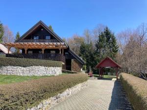 a house with a stone wall next to a walkway at Cozzy cottage near Ljubljana in Višnja Gora