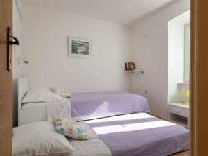 - 2 lits dans une petite chambre avec des draps violets dans l'établissement Holiday Home Anima Maris- Duplex Two Bedroom Holiday Home with Terrace and Sea View, à Ston