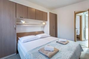 a bedroom with a large bed with towels on it at Apartments Sonja - Two Bedroom Apartment with Balcony and Garden View A3 2 ST in Pučišća
