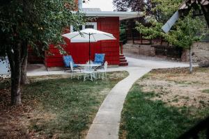 刘易斯顿Old World Charm River Views的房子前面的一张桌子、几把椅子和一把遮阳伞