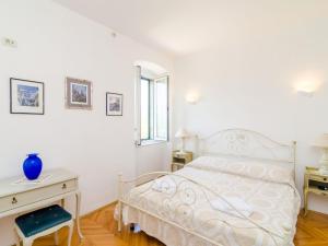 a white bedroom with a bed and a desk at Stone House ''DiMaTo'' - Four Bedroom Holiday Home with Terrace in Gruda