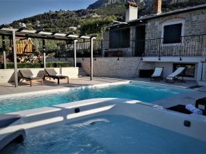 克利斯Villa Manda Korina - Three-Bedroom Villa with Private Pool的一个有两把椅子的游泳池和一栋房子