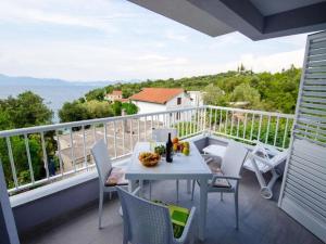 a balcony with a table and chairs and the ocean at Apartments Vesela - Comfort One Bedroom Apartment with Balcony and Sea View in Janjina