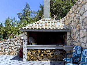 a outdoor oven with a pile of fire wood at Apartments Vesela - Comfort One Bedroom Apartment with Balcony and Sea View in Janjina
