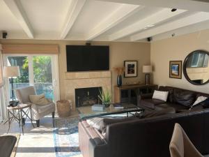a living room with a couch and a fireplace at SurfCity Villa Chateau Relaxeau in Huntington Beach