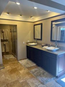 a bathroom with two sinks and a mirror at SurfCity Villa Chateau Relaxeau in Huntington Beach