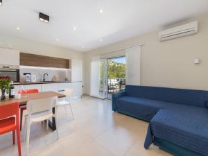 a living room with a blue couch and a table at Apartments Ema-Comfort Two Bedroom Apartment with Sea View Fancy in Rogotin