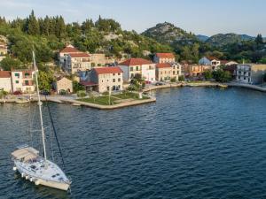 a sailboat is docked in the water near a town at Apartments Ema-Comfort Two Bedroom Apartment with Sea View Fancy in Rogotin