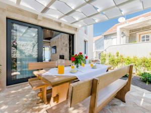 a patio with a table and benches at Villa Stone Pearl - Two Bedroom Holiday House with Pool in Sutivan