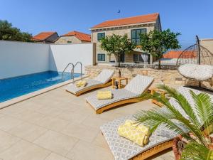a patio with chairs and a swimming pool at Villa Stone Pearl - Two Bedroom Holiday House with Pool in Sutivan