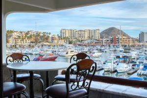 a table and chairs on a balcony with a marina at Completely Remodeled 2BD-2BA Plaza Bonita in Cabo San Lucas