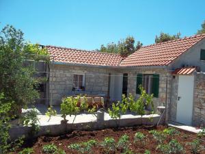 a stone house with a table and chairs in a garden at Holiday Home in Mirca with terrace in Mirce