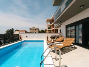 un patio con tavolo e sedie accanto alla piscina di Villa La Ze - Three Bedroom Villa with Swimming Pool a Rogoznica (Rogosnizza)