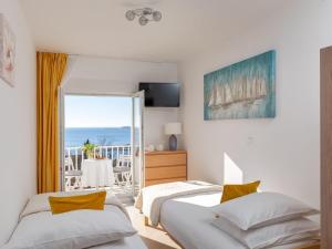 two beds in a bedroom with a view of the ocean at 2 room apartment with hot tub in Mlini