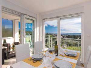 a white dining room with a table with a view at Apartment Salvagno - Two Bedroom Apartment with Balcony and Sea View in Punat
