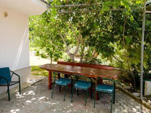 a wooden table and four chairs under a pergola at Apartments Bandalo - Standard Studio Apartment in Podstrana