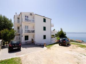 a white building with two cars parked in front of it at Apartments Bandalo - Standard Studio Apartment in Podstrana