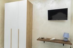 Una sala de estar con un televisor en la pared. en Civico 44, en Nápoles