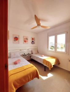 a bedroom with two beds and a ceiling fan at " Villa Rían " Mar Menor Golf Resort in Murcia