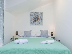a bedroom with a green bed with two pillows at Holiday home Barbara - Two Bedroom Holiday home in Ston