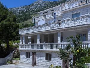 un grand bâtiment avec des balcons blancs au sommet dans l'établissement Apartments Villa Dinga -Borak - Two Bedroom Apartment with Terrace No 1, à Potomje