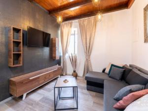 a living room with a couch and a tv at Stone House Prapatna-Two Bedroom Holiday Home with Swimming Pool in Smokvica