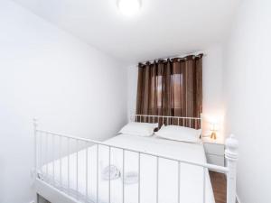 a white bedroom with a crib and a window at Stone House Prapatna-Two Bedroom Holiday Home with Swimming Pool in Smokvica +35 photos