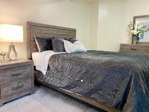 a bedroom with a bed with a black comforter and pillows at Waterfront Eagle Nest in Nanaimo