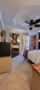 Caye Caulker Boutique Guesthouse 5 في كاي كولكر: غرفة نوم بها سرير ومروحة سقف