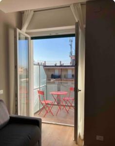a room with a balcony with a table and chairs at Monolocale nuovo arredato vista mare in Valverde