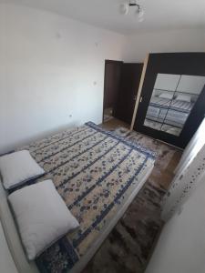 een leeg bed in een kamer met een spiegel bij Levkov in Petrich +17 foto's