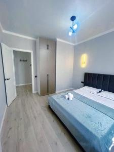 a bedroom with a large bed with a blue blanket at Apart Astana, Комплекс Sat City рядом с Хан-Шатыром in Astana