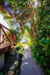 a path with a tree and a bench and a car at The Yellow Door Guesthouse in East London