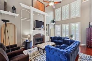 Elle comprend un salon doté d'un mobilier bleu et d'une cheminée. dans l'établissement Elegant & Luxurious 4BD Living w Pool Patio BBQ, à Plano