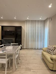 un soggiorno con un tavolo e un divano di Casa Erminia a Caserta